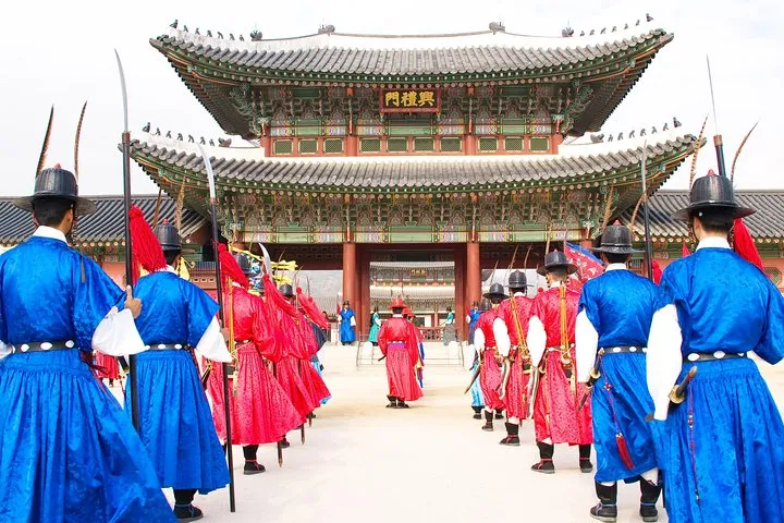 Royal guards in Joseon uniforms at the Gyeongbokgung gate on a full-day private city tour, one of the seoul private tours